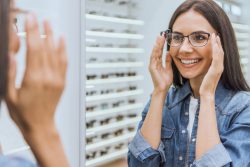 Partial,View,Of,Smiling,Woman,Choosing,Eyeglasses,And,Looking,At
