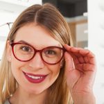 Attractive,Young,Woman,Choosing,Eyeglass,Frame,In,An,Optical,Store